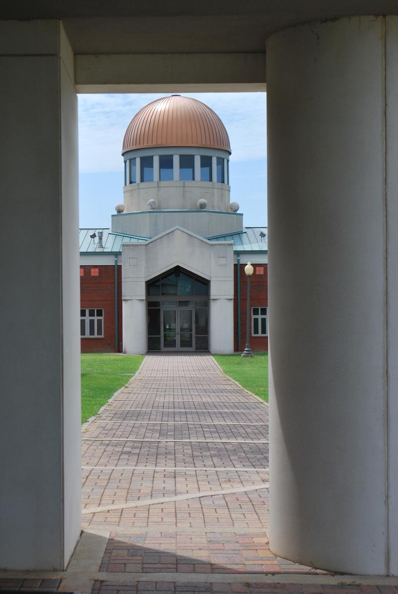 A view of an SUSCC building from between two columns in the foreground.