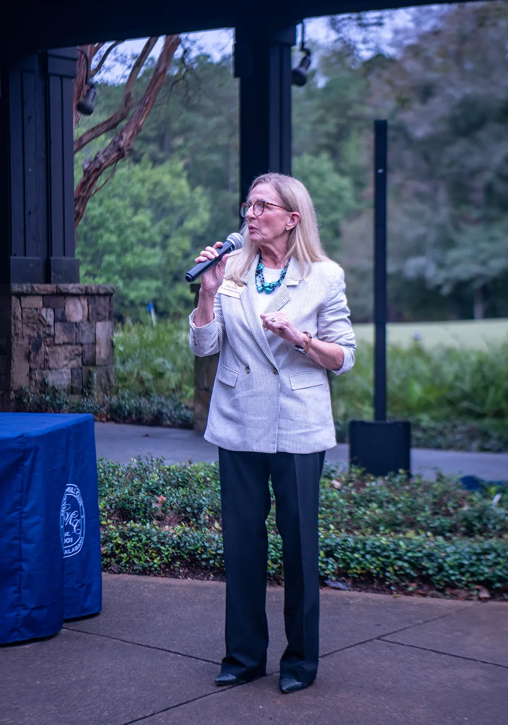 Well dressed woman speaking with a microphone